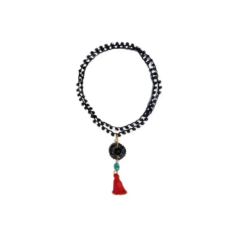 Collar negro con criSoundales metálicos con dije de esfera, calaOthersra y borla